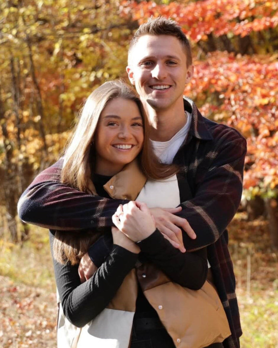 First Key founders John and Halle hugging in an autumn forest